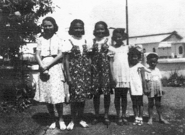 De zes kinderen Jacobs (geheel rechts: Edward) in de voortuin van de woning op het terrein van de suikeronderneming Tjepiring  Foto: privécollectie Edward Jacobs